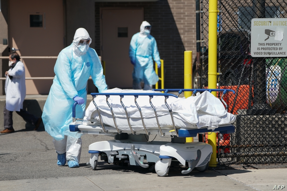 Bodies are moved to a refrigeration truck serving as a temporary morgue at Wyckoff Hospital in the Borough of Brooklyn on April 6, 2020 in New York. - New York Governor Andrew Cuomo on Monday extended a shutdown in the epicenter of America's deadly coronavirus pandemic until near the end of the month. Cuomo said the COVID-19 death rate in New York was "effectively flat" for the past two days but announced that schools and non-essential businesses must stay shut until April 29. (Photo by Bryan R. Smith / AFP)
