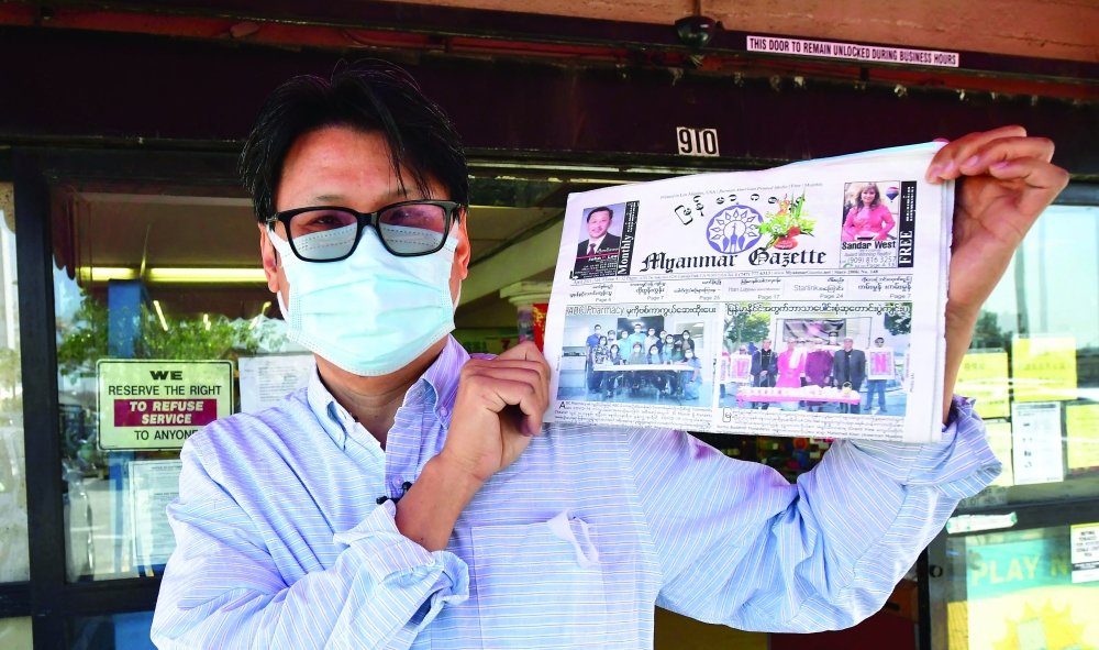 Editor and publisher Thakhin Kai Bwor displays the latest copy of the Myanmar Gazette before distributing it to Asian supermarkets in the San Gabriel Valley city of Alhambra in Los Angeles County, California. - AFP
