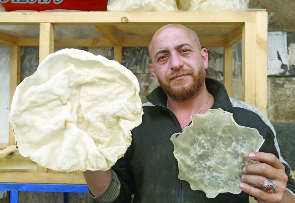 A Syrian vendor displays the pancake which makes up the traditional sweet known as 'Al Naem', commonly served during Ramadhan in Damascus' Shaqhoor neighbourhood. - AFP