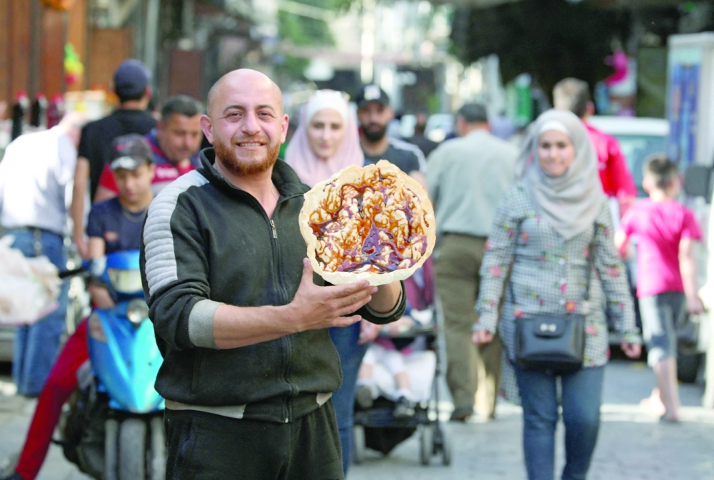 A Syrian vendor displays the pancake which makes up the traditional sweet known as 'Al Naem', commonly served during Ramadhan in Damascus' Shaqhoor neighbourhood. - AFP
