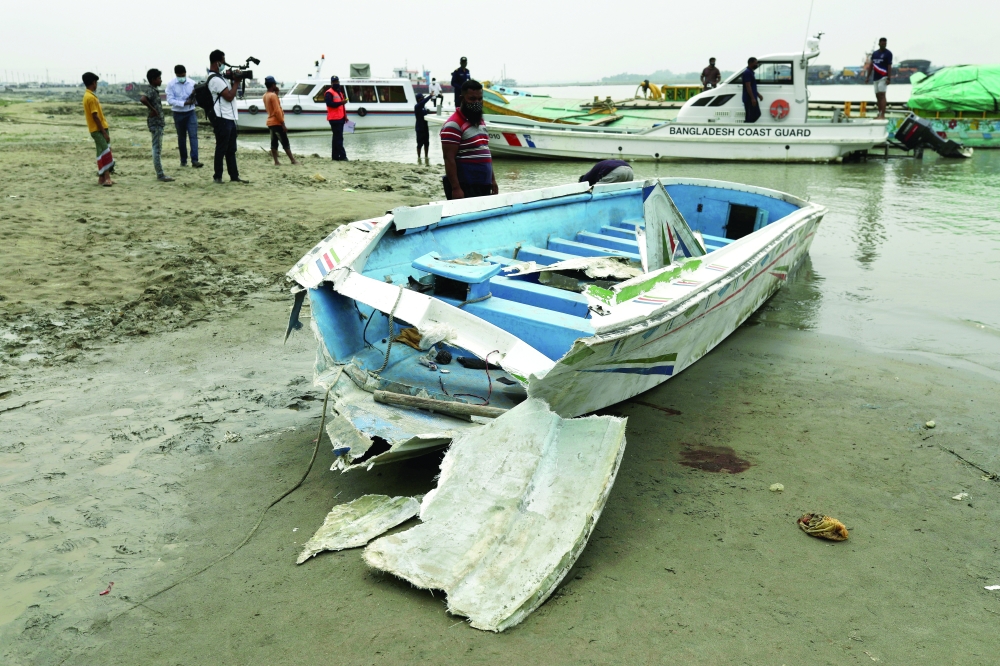 A speedboat is seen ashore after it collided with a sand-laden bulk carrier and sank on Padma River in Madaripur, Bangladesh. - Reuters