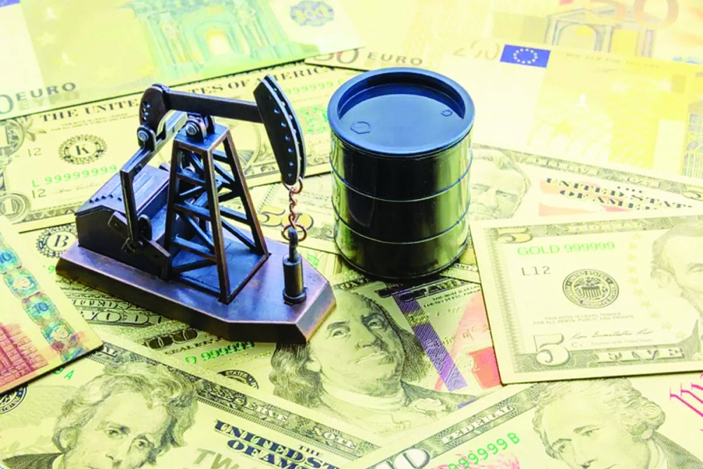 A pump jack and a black barrel placed on top of US dollar notes are seen in this illustration picture. — AFP