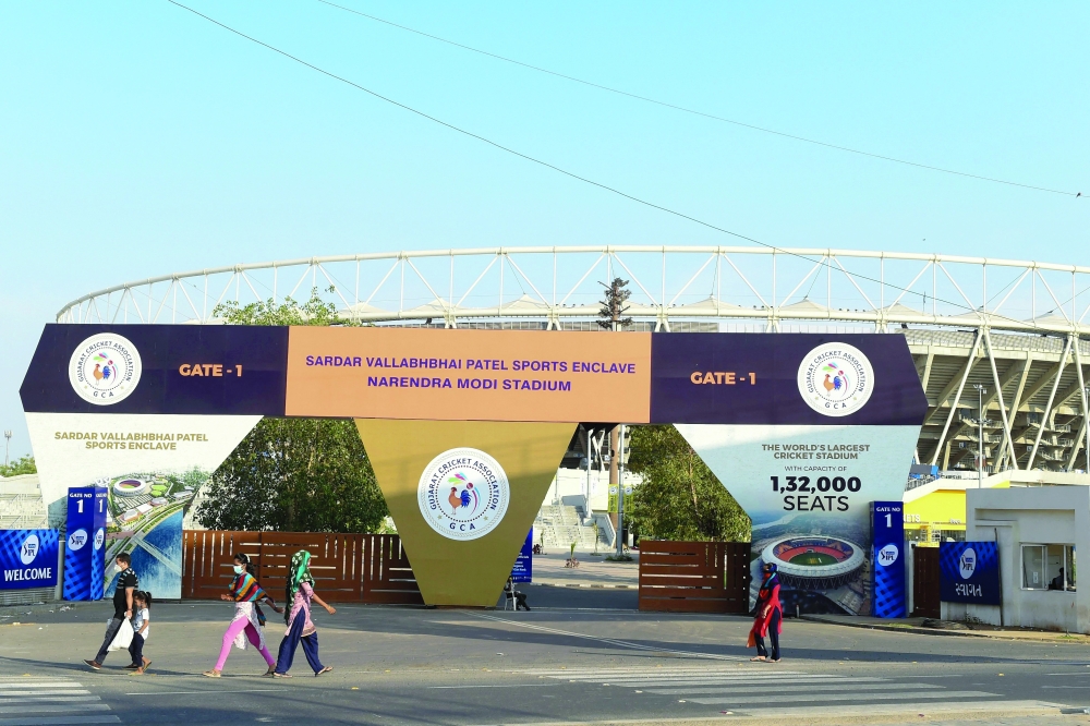 People make their way past the main entrance of the Narendra Modi Stadium, a venue of the 2021 Indian Premier League (IPL), in Motera. -- AFP