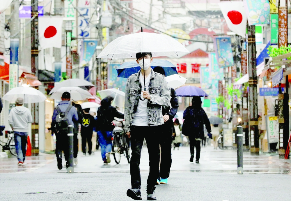 A man wearing a protective face mask, amid the Covid-19 pandemic, makes his way at a local shopping street in Tokyo, on Wednesday. - Reuters