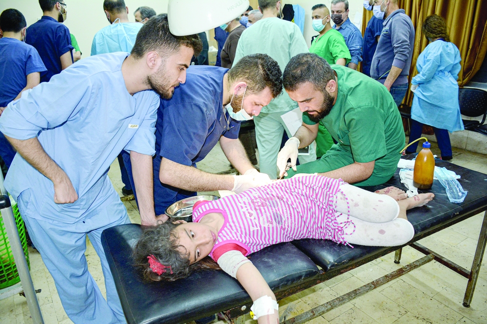 An injured girl is treated after pre-dawn raids on the Mediterranean port region of Latakia, Syria, in this handout picture released on Wednesday. - Reuters 