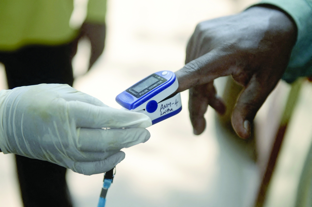 A health worker uses an oximeter to monitor the pulse an oxygen saturation levels of a resident during a door-to-door survey to check for coronavirus symptoms in Hyderabad. - AFP 
