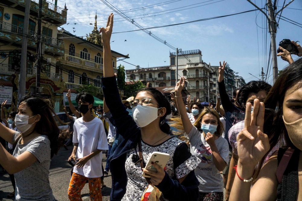 Protesters make the three-finger salute during a demonstration against the military coup in Yangon. - AFP 