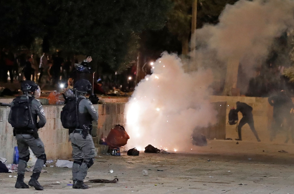 Tear gas billows amid clashes between Israeli security forces and Palestinian protesters at the Al Aqsa mosque compound in Jerusalem. - AFP 
