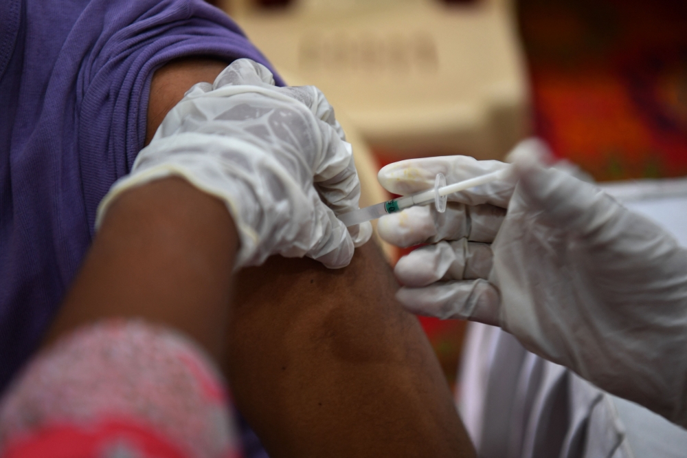 A medical worker inoculates a man with a dose of the Covaxin vaccine against the coronavirus at a vaccination centre in Mumbai. - AFP