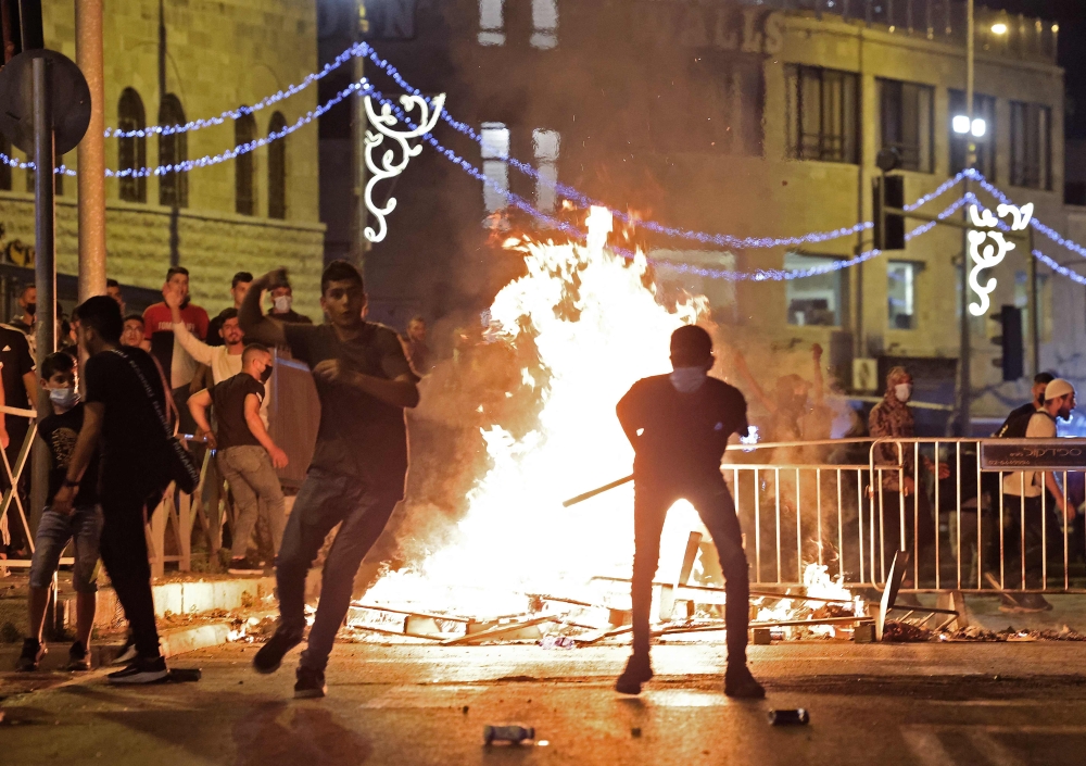  Palestinian protesters hurl stones at Israeli security forces amid clashes in Jerusalem's Old City. - AFP