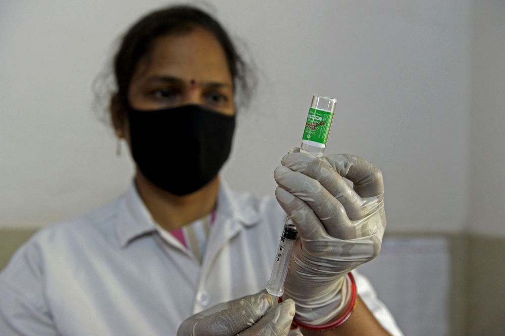A health worker prepares to inoculate a person with the second dose of the Covishield vaccine in Hyderabad. 

