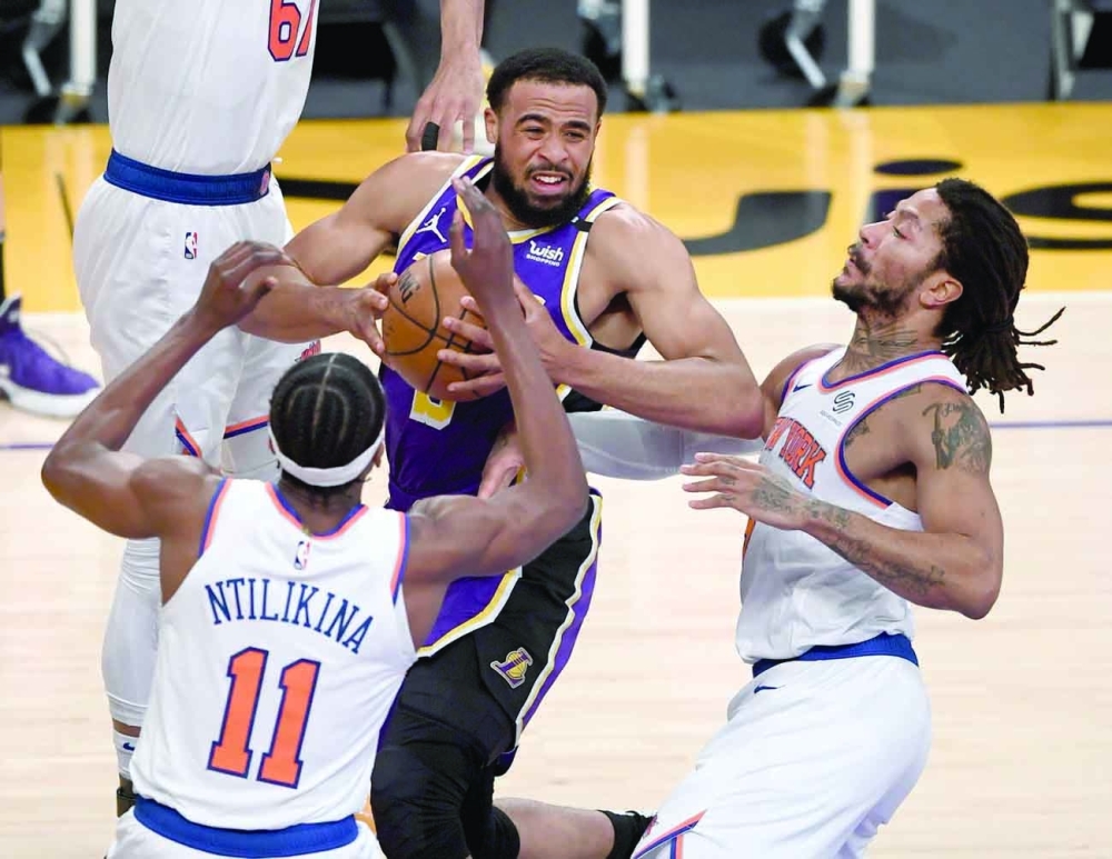 Los Angeles Lakers' Talen Horton-Tucker (5) drives to the basket while defended by New York Knicks' Taj Gibson (67) and Derrick Rose (40 at Staples Center. -- USA Today Sports
