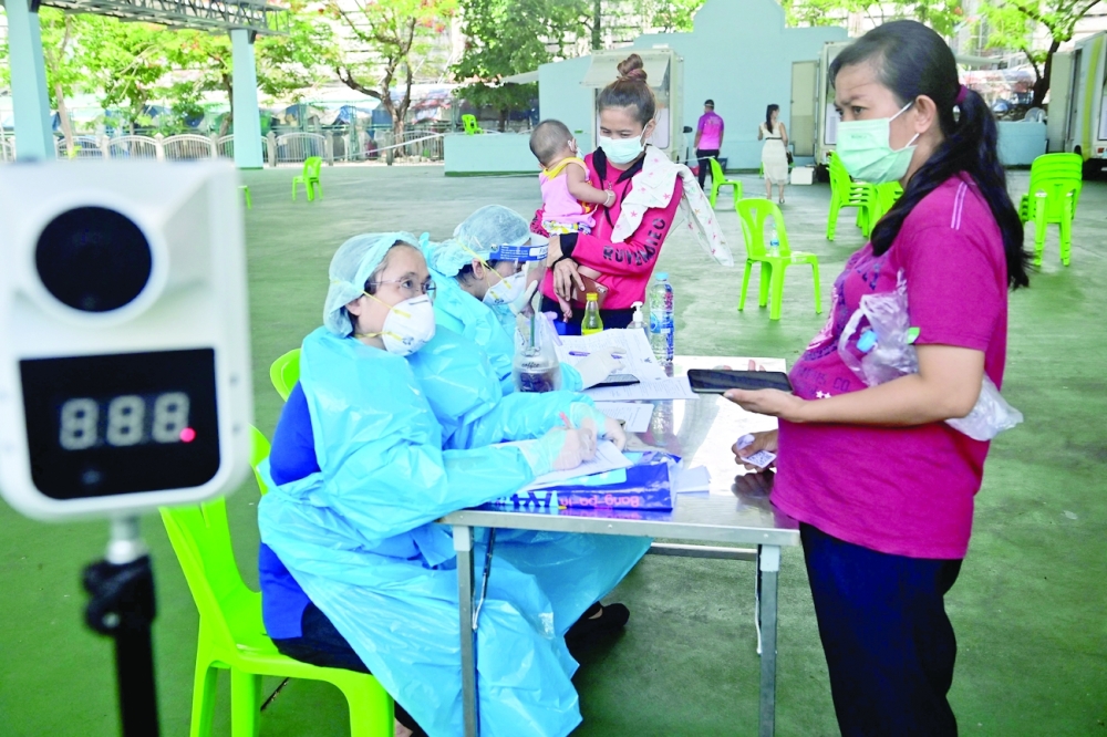 Residents of the Huay Kwang community register for nasal swab tests for the coronavirus at a mobile clinic in a sports stadium in Bangkok. - AFP