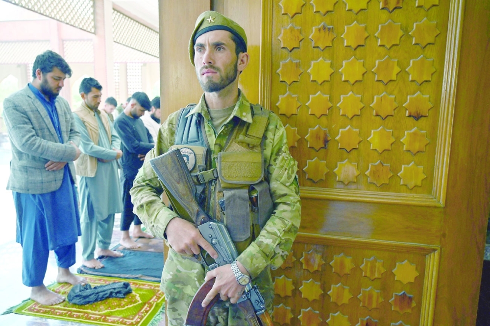 An Afghan security personnel stands guard as devotees offer prayers to start the Eid al Fitr festival marking the end of Ramadhan during a three-day ceasefire at the Abdul Rahman Mosque in Kabul. - AFP 