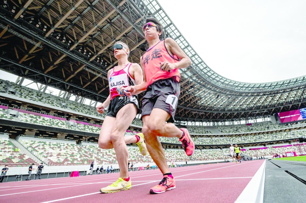 Hiroaki Kajisa (L) of Japan and his guide Satoshi Toyoshima compete in the men's 1500m - T11 category during a para-athletics test event for the 2020 Tokyo Olympics. -- AFP