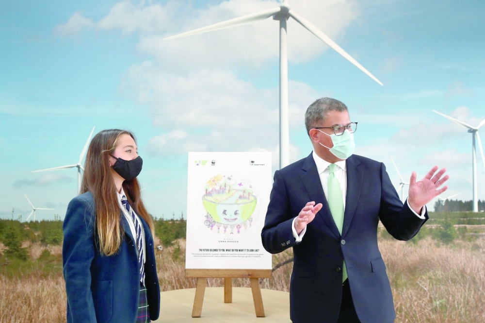 COP26 President Alok Sharma gestures next to Emma Khadeh and her winning art competition piece, during an event at Whitelee Windfarm, marking six months until the UN Climate Change Conference, outside Glasgow, Scotland. - Reuters
