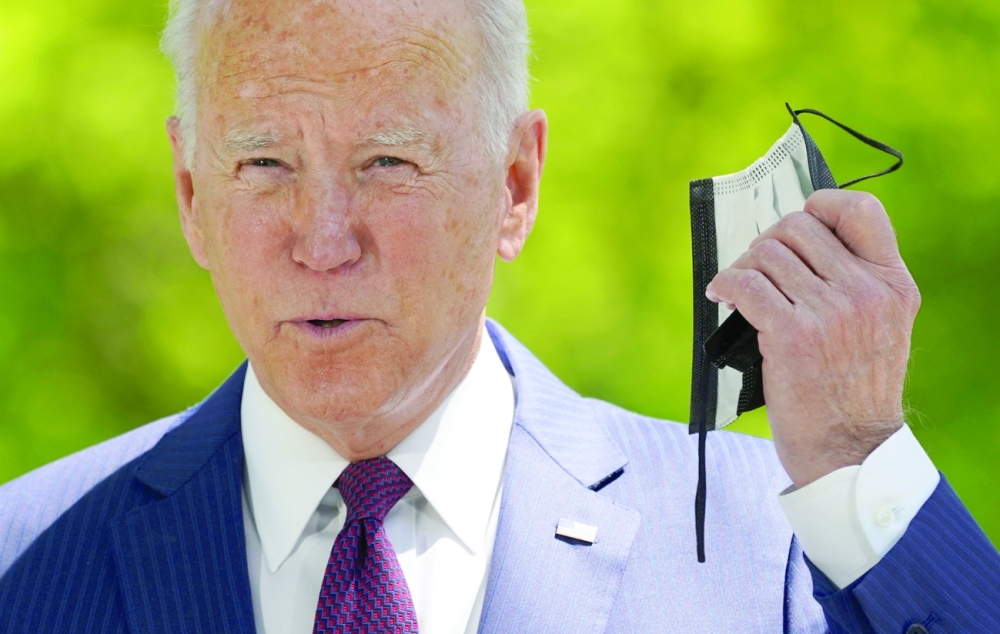 US President Joe Biden pulls off his face mask as he arrives to speak about loosening coronavirus disease mask guidelines while delivering an update on the administration's pandemic response outside the White House in Washington. - Reuters File Photo