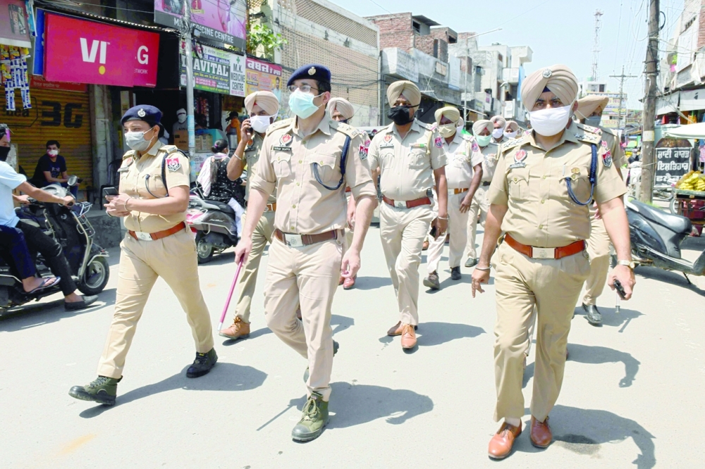 Police personnel patrol through a market area during a lockdown imposed to curb the spread of the coronavirus at a village on the outskirts of Amritsar. - AFP 