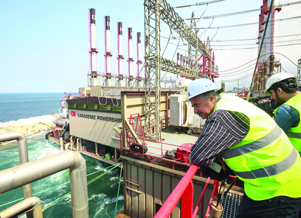 Lebanese journalists on a guided tour standing aboard the Turkish-owned MV Karadeniz Powership Fatmagul Sultan viewing the other powership Esra Sultan, both moored off the shore of the Lebanese town of Zouk Mosbeh, north of the capital Beirut. - AFP File Photo