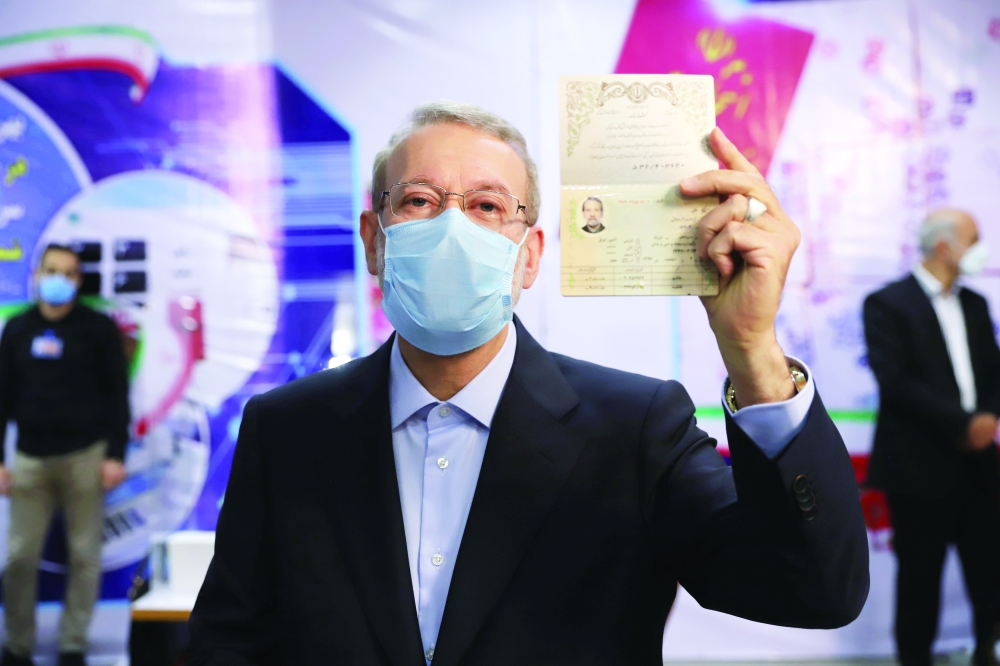 Ali Larijani, former chairman of the parliament of Iran, shows his identification document as he registers as a candidate for the presidential election in Tehran. - Reuters