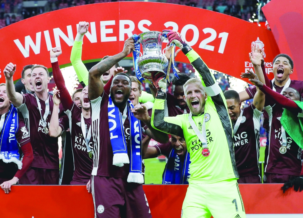 Leicester City's Kasper Schmeichel (R) and Wes Morgan celebrate winning the FA Cup with teammates. -- Reuters