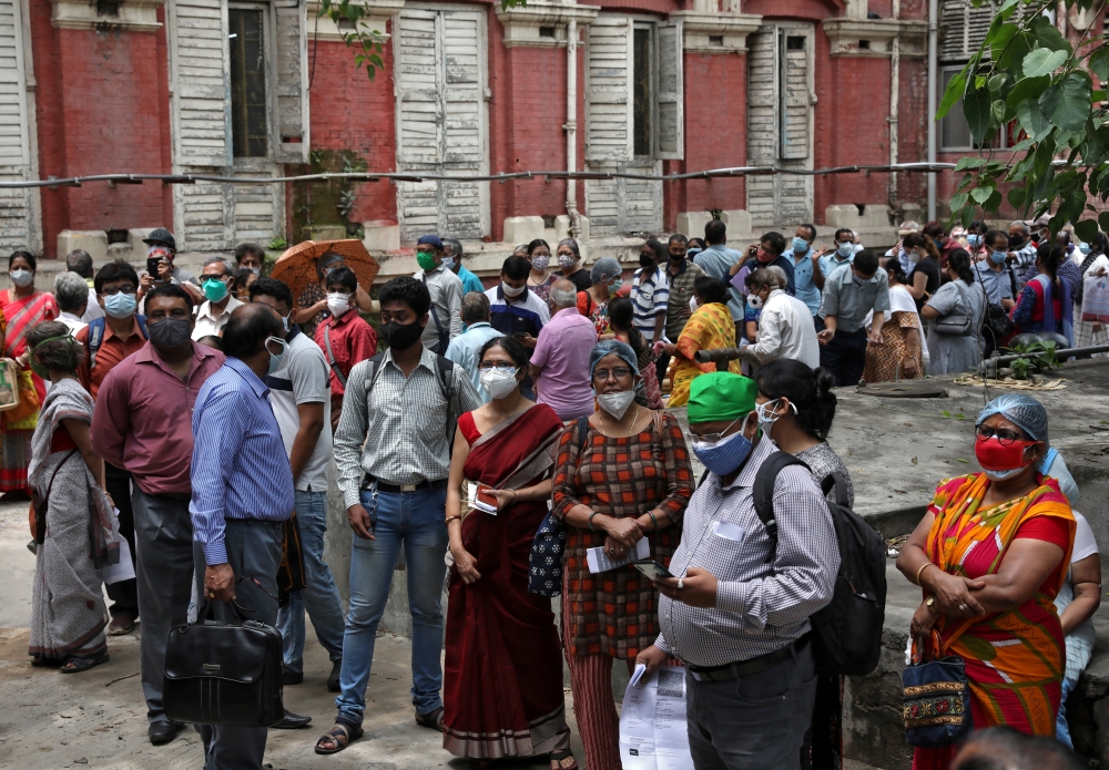 People wearing protective face masks wait to receive their second dose of vaccine manufactured by Serum Institute of India