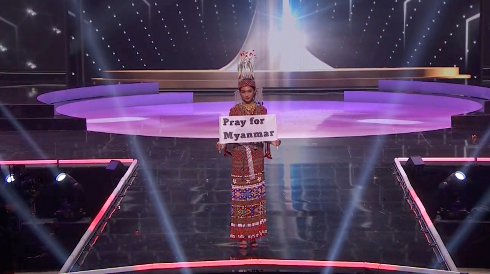 Ma Thuzar Wint Lwin, Miss Universe Myanmar, holds the "Pray for Myanmar" sign during Miss Universe pageant's national costume show, in Hollywood, Florida, U.S.