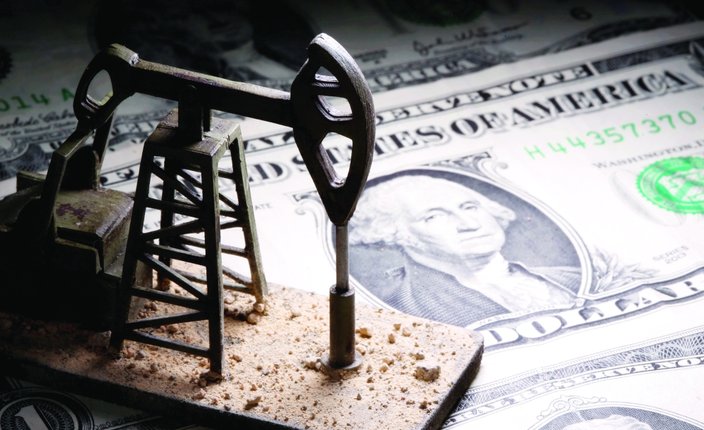 A 3D printed oil pump jack is placed on dollar banknotes in this illustration picture. — Reuters