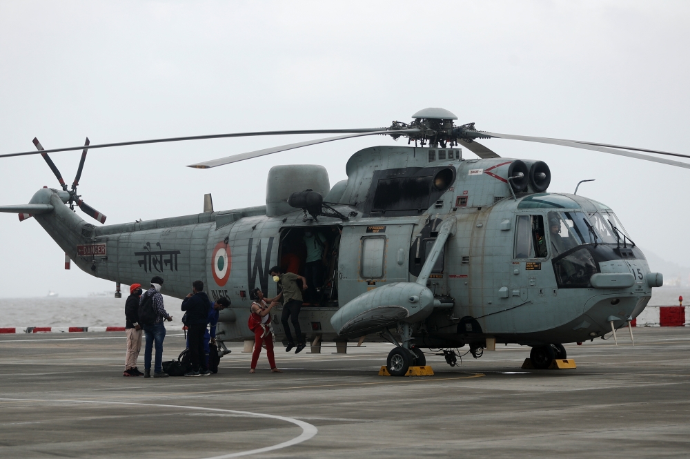 People who were stranded at sea due to Cyclone Tauktae exit an Indian Navy Sea King Mk.42C helicopter, after they were rescued by the Indian Navy, at INS Shikra, Colaba, Mumbai, India, May 18, 2021. REUTERS/Francis Mascarenhas
