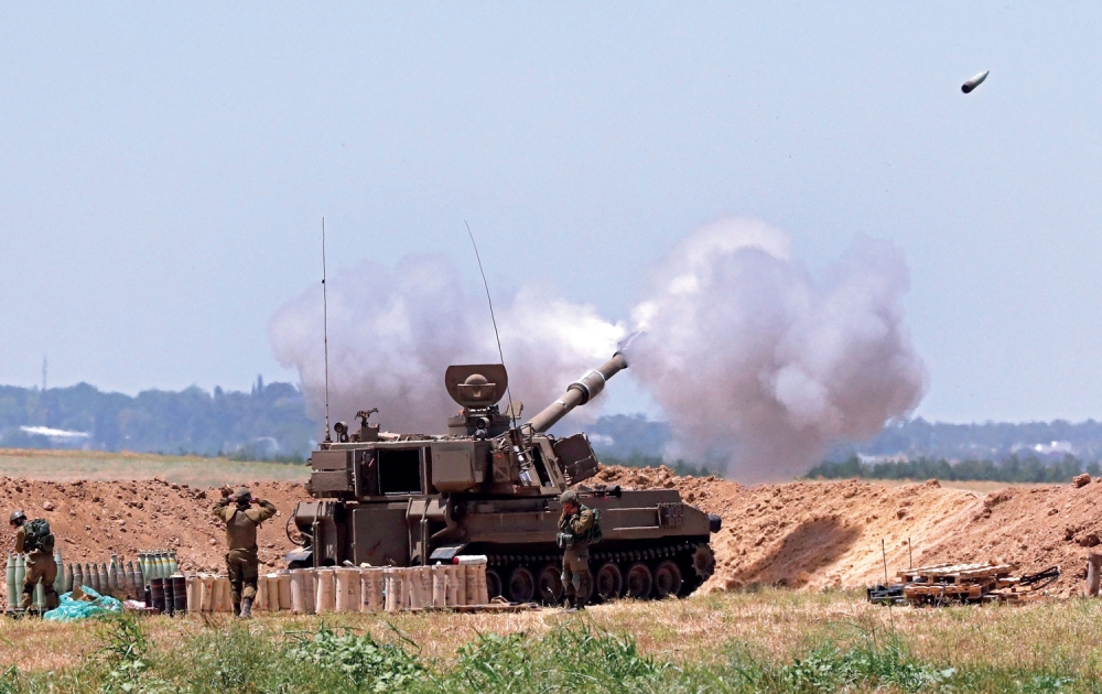 Israeli soldiers fire artillery shells towards the Gaza Strip from their position along the border with the Palestinian enclave on Wednesday. — AFP