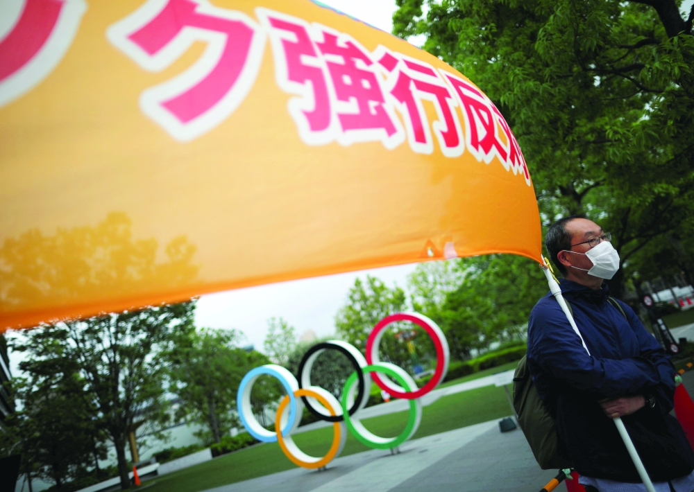 An anti-Olympics group member holds a banner during a protest outside the Japanese Olympic Committee headquarters. -- Reuters