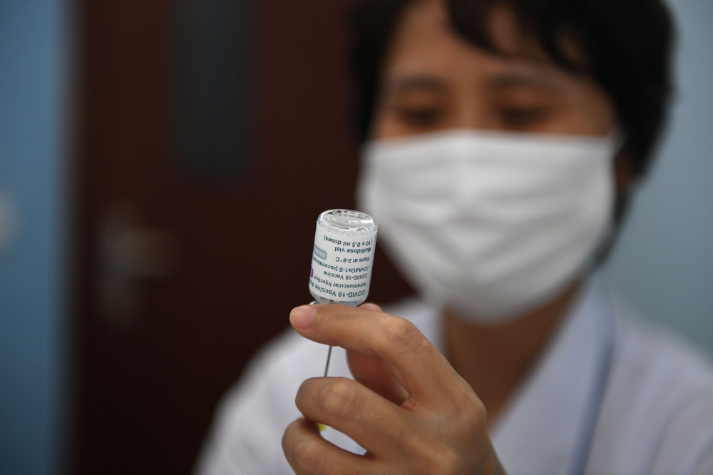 A health worker prepares a dose of the AstraZeneca vaccine for the Covid-19 coronavirus at the Bach Mai Hospital in Hanoi on May 17, 2021. / AFP / Nhac NGUYEN

