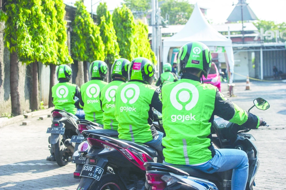 Gojek riders wait for their delivery orders at a distribution centre in Surabaya as Gojek and Tokopedia unveiled a merger to form GoTo Group. - AFP