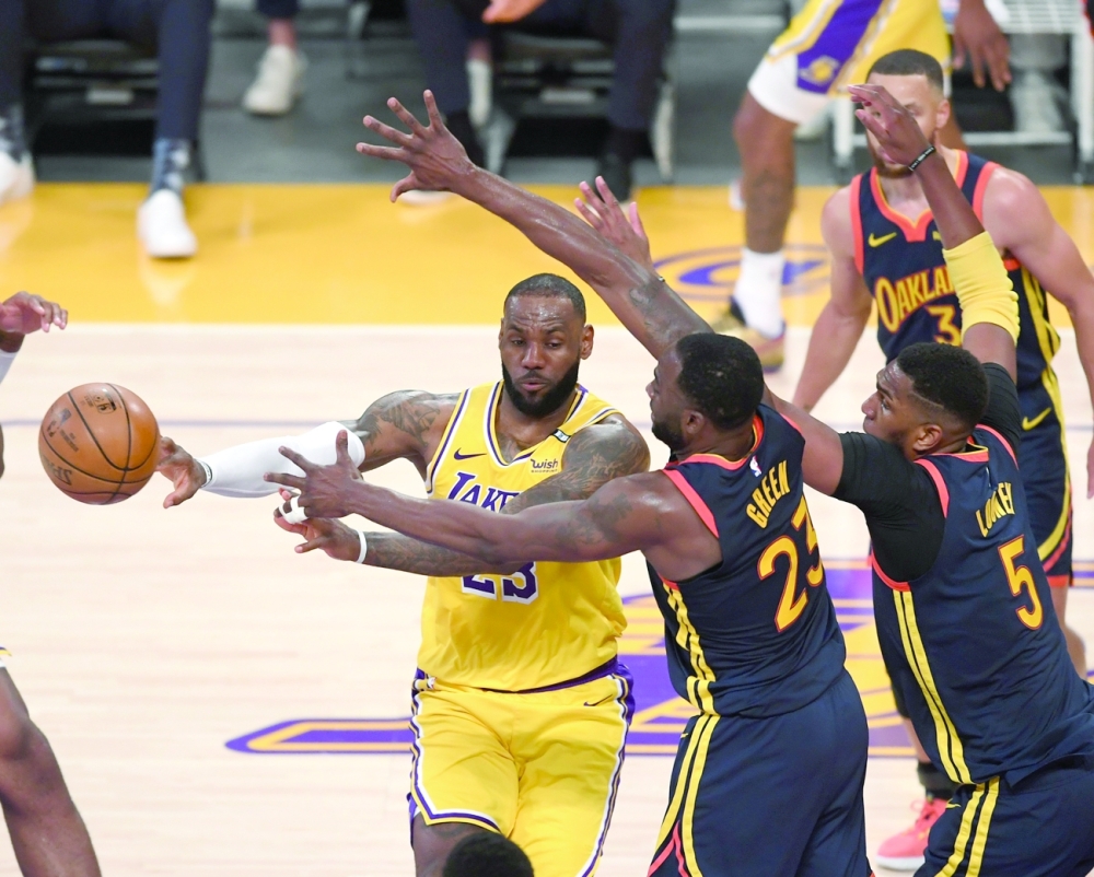 Golden State Warriors' Draymond Green (23) and Kevon Looney (5) defend Los Angeles Lakers' LeBron James (23) under the basket at Staples Center. -- USA Today Sports
