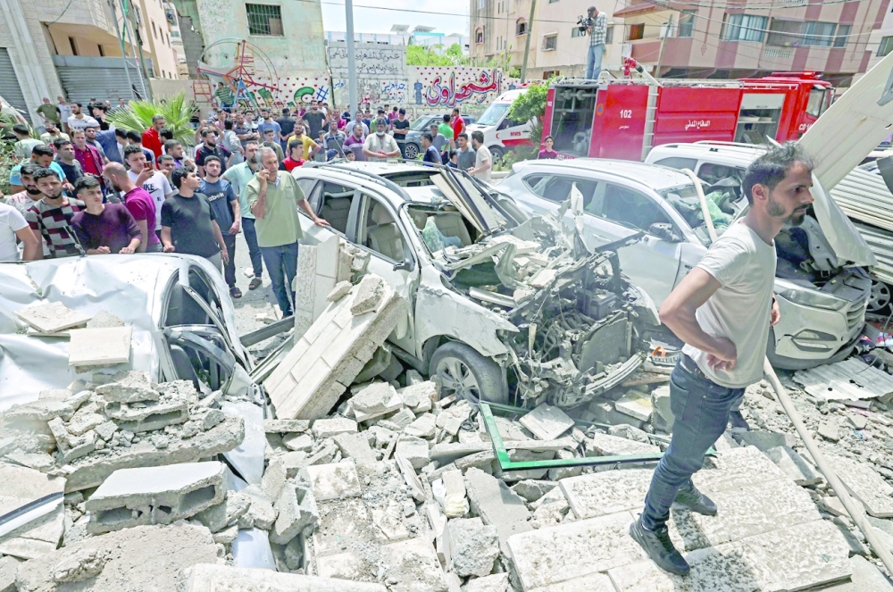 Palestinians inspect a site hit during an Israeli airstrike in Gaza City. - AFP