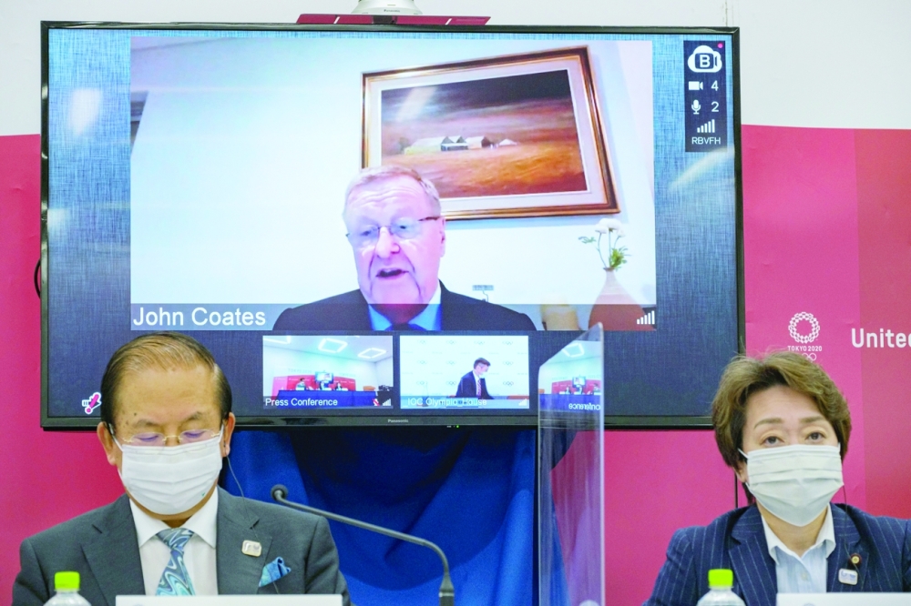 Tokyo 2020 CEO Toshiro Muto, Tokyo 2020 President Seiko Hashimoto and IOC Coordination Commission Chairman John Coates remotely on-screen, attend a news conference in Tokyo. -- Reuters