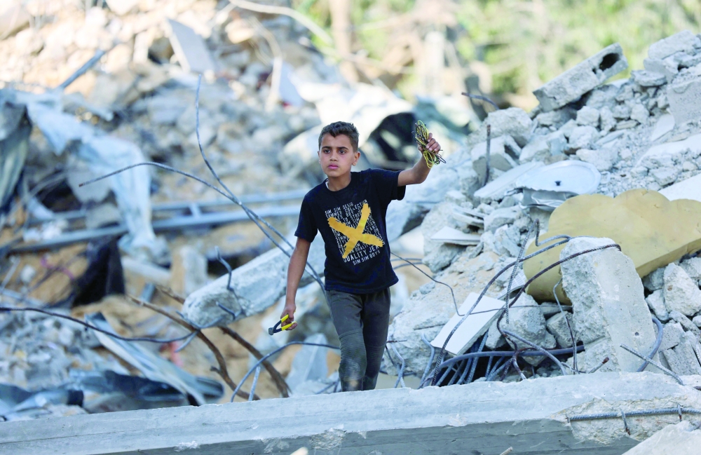 A Palestinian boy inspects the rubble of buildings destroyed by Israeli strikes in Beit Lahia in the northern Gaza Strip. - AFP
