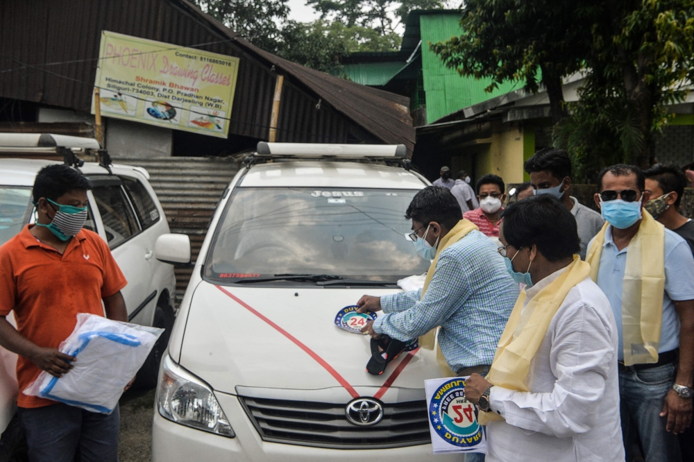 A doctor places a sticker on private vehicles converted into ambulances for Covid-19 patients, during a lockdown imposed
in India. 