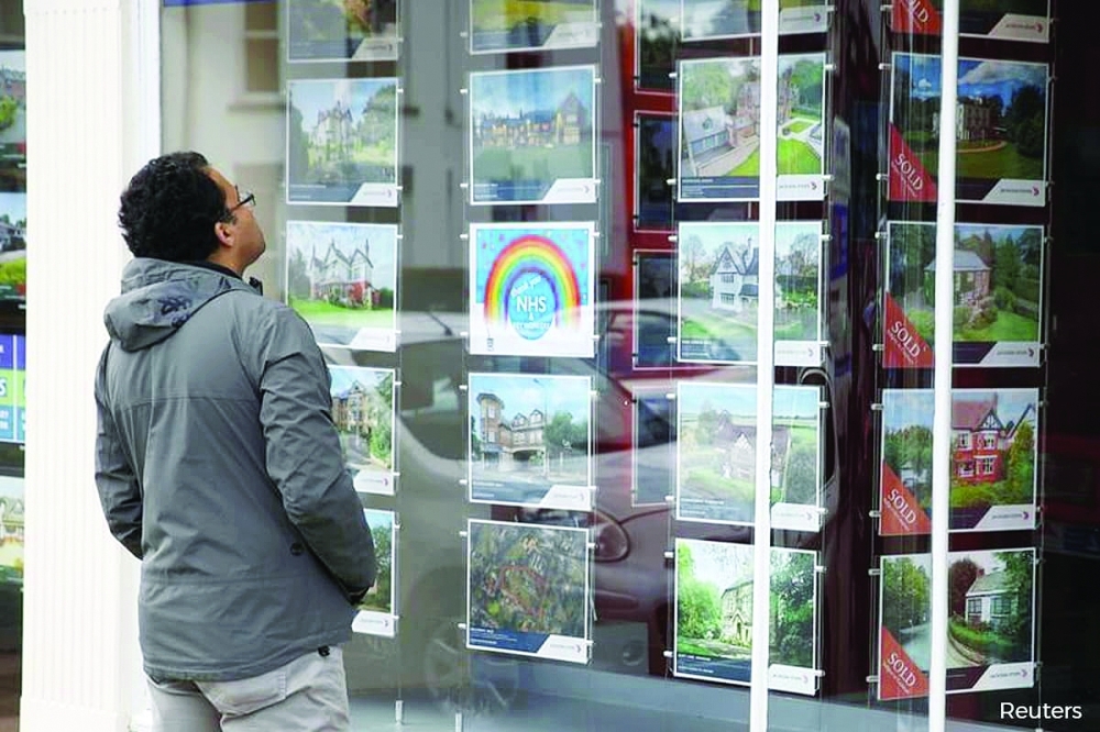 A man looks at advertisements for property for sale in central London. — Reuters