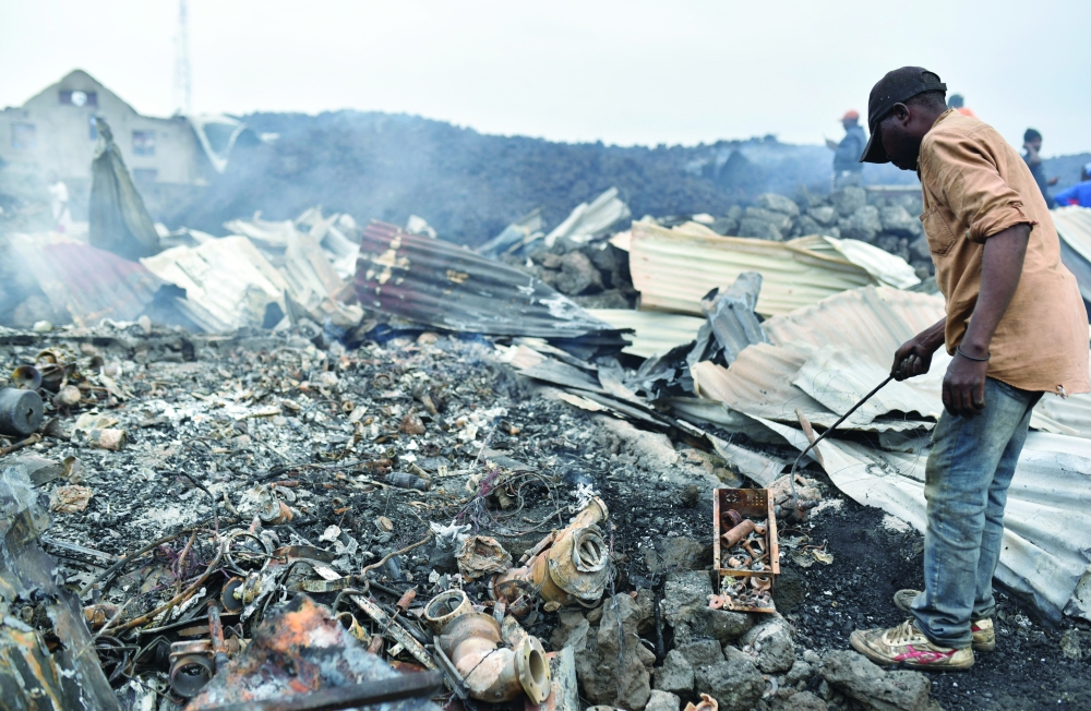 Residents pick up remains of their destroyed homes from the smouldering lava deposited by the eruption of Mount Nyiragongo volcano near Goma on Sunday. - Reuters