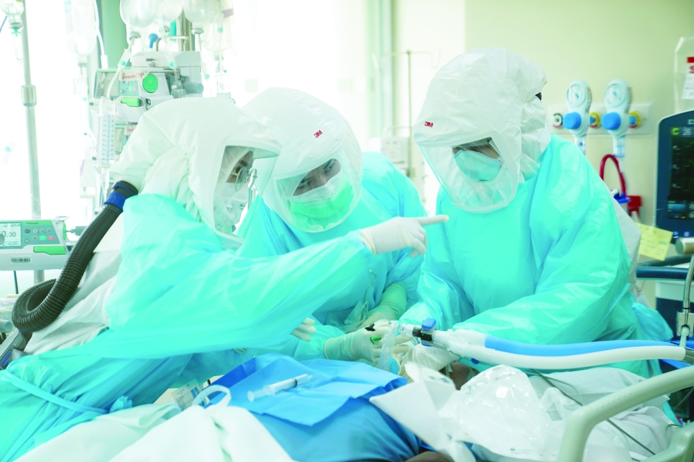 A doctor and ICU nurses wearing personal protection equipment (PPE) treat a patient suffering from Covid-19 in the Intensive Care Unit (ICU) at the King Chulalongkorn Memorial Hospital in Bangkok.  Reuters