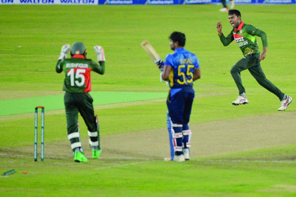 Bangladesh's Mehidy Hasan Miraz (R) celebrates after taking the wicket of Sri Lanka's captain Kusal Perera (C) during the first one-day international (ODI) cricket match between Bangladesh and Sri Lanka at the Sher-e-Bangla National Cricket Stadium in Dhaka. -- AFP
