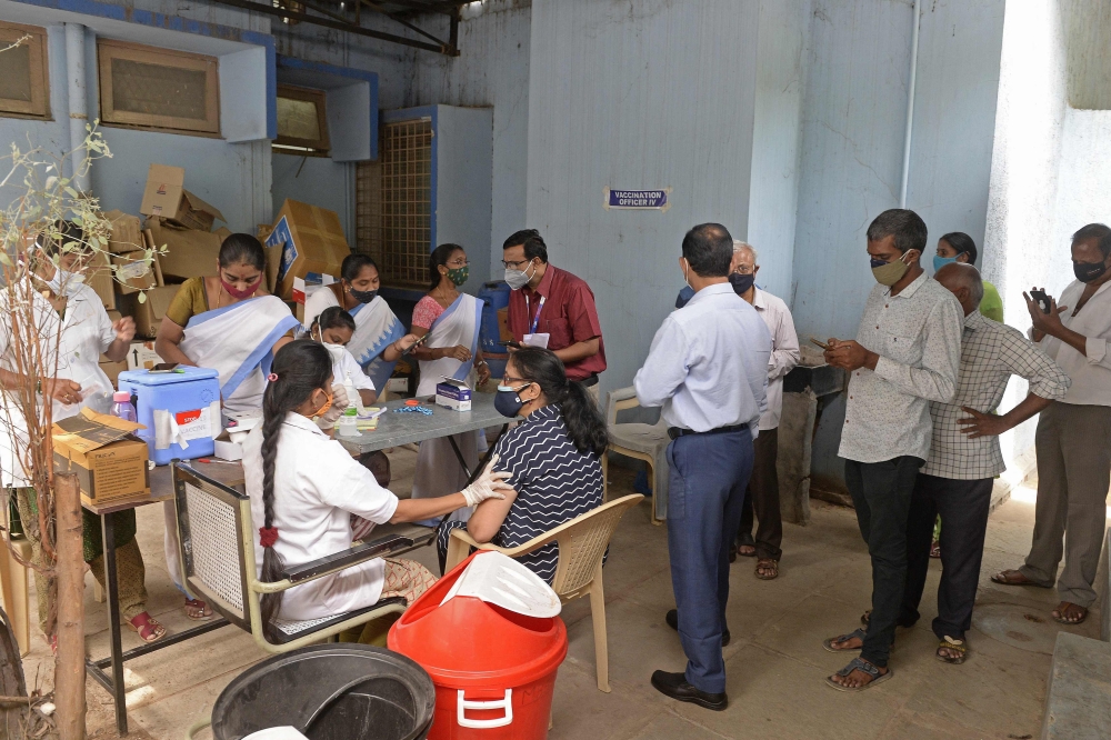 People queue up and register themselves to get inoculated with the Covid-19 coronavirus vaccine at a primary health centre in Hyderabad on May 25, 2021. 
