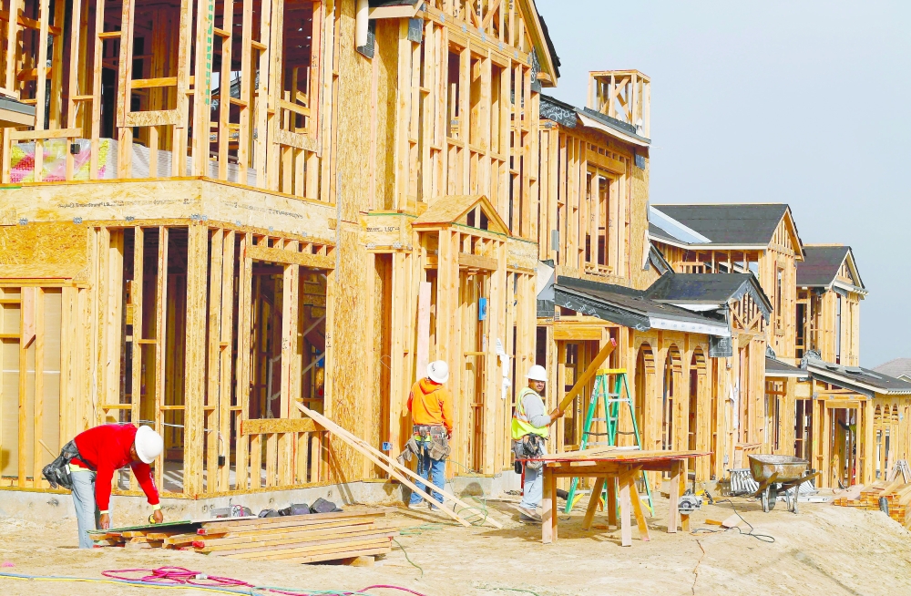 Construction workers build single homes in San Diego, California. — Reuters
