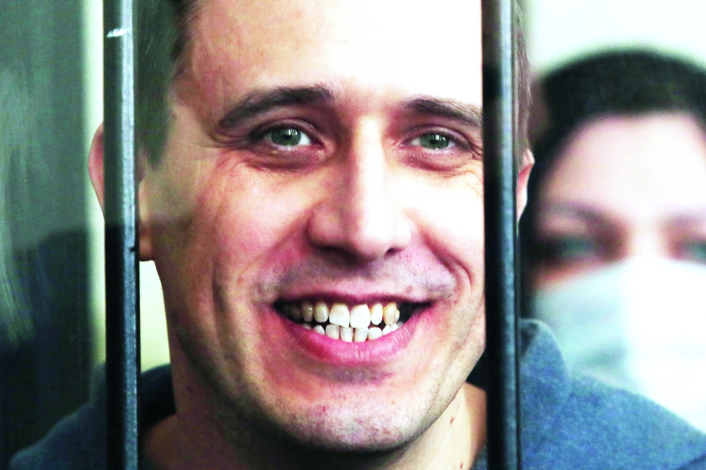 Belarus opposition figure Pavel Severinets smiles from the defendant’s cage at a courthouse in the town of Mogilev, some 200 km east of Minsk, on May 25, 2021, as he and six fellow co-defendants activists were sentenced to jail terms of four to seven years in a trial held behind closed doors, after being found guilty of taking part in “mass unrest”, referring to the historic protests that erupted after a disputed presidential election last August. — AFP