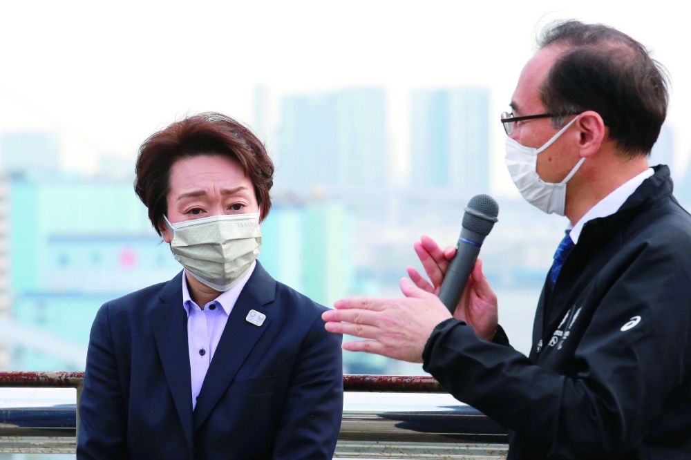 Seiko Hashimoto, president of the Tokyo 2020 Organising Committee, listens as Masayuki Kanda, Tokyo 2020 Elective Director of Transport speaks, during her visit to Tsukiji Depot, Tokyo. -- AFP