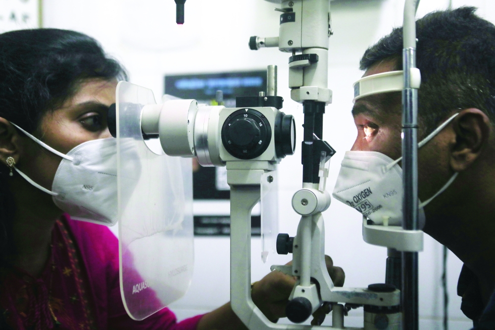 A doctor checks a patient for mucormycosis symptoms using a slit lamp at a hospital in Mumbai on Tuesday. — Reuters