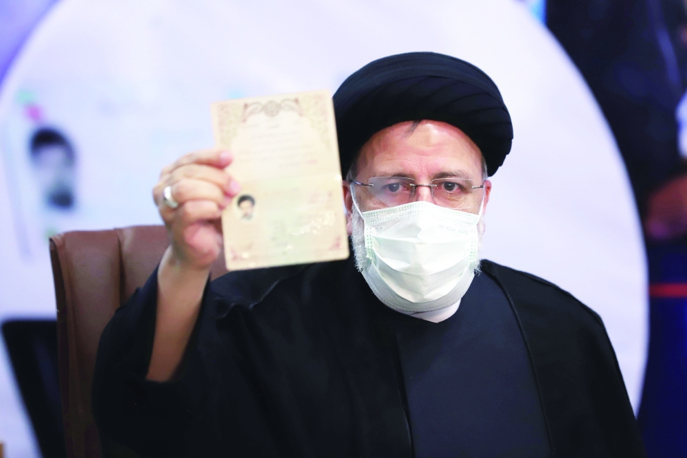Ebrahim Raisi, Chief Justice of Iran, shows his identification document as he registers as a candidate for the presidential election at the Interior Ministry, in Tehran. — Reuters file photo