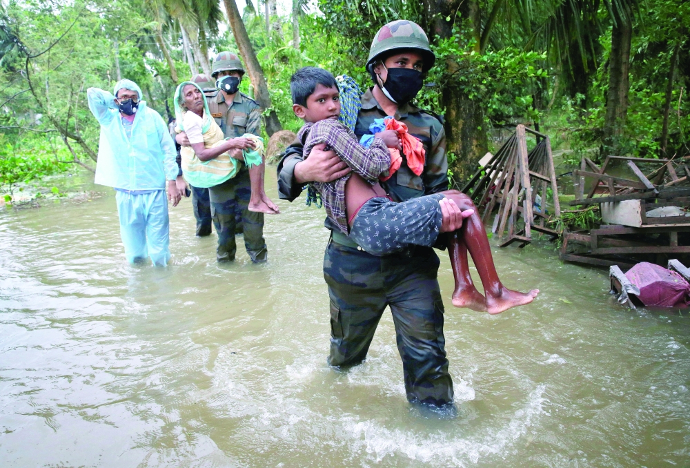 Army soldiers evacuate people from a flooded area to safer places as Cyclone Yaas makes landfall at Ramnagar in Purba Medinipur district in West Bengal on Wednesday. Reuters