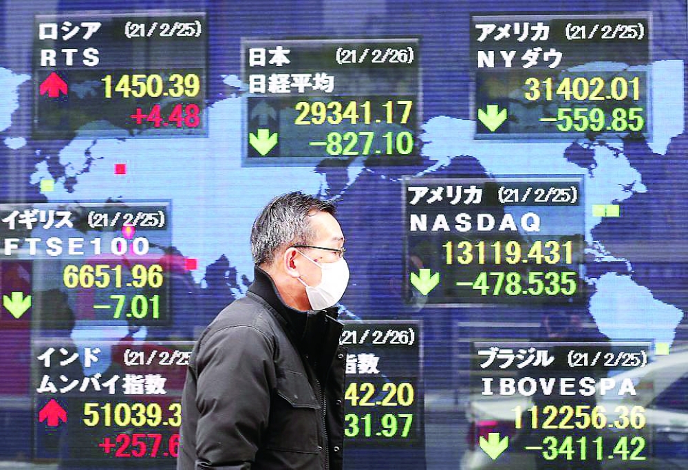 A man walks past a stock quotation board at a brokerage in Tokyo. - Reuters
